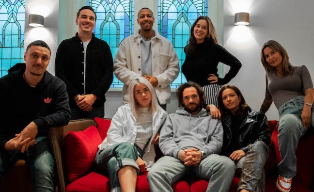 The team standing in the image (L-R): Sander Stijnen (Head of A&R and ADA Benelux), Patrice Boone (Brand Manager, Hip-Hop), Margot Bastiaans (A&R Coordinator).  The team sitting in the image (L-R): Amier Kalaeli (Brand Manager Hip-Hop), Lotte Sterk (A&R Manager), Freek Clinckemaillie (A&R consultant), Ixia Verdooren (Head of Domestic Marketing Benelux), Joel Brendgen (A&R consultant).